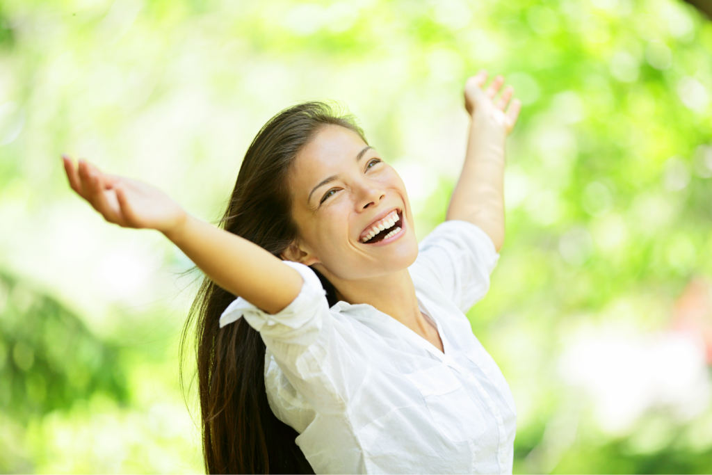 Mujer abriendo los brazos abrazando el bienestar de la naturaleza