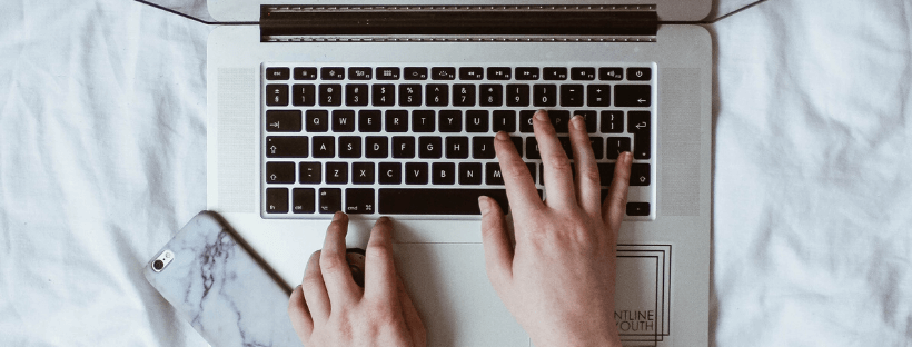 mano escribiendo sobre el teclado de una laptop