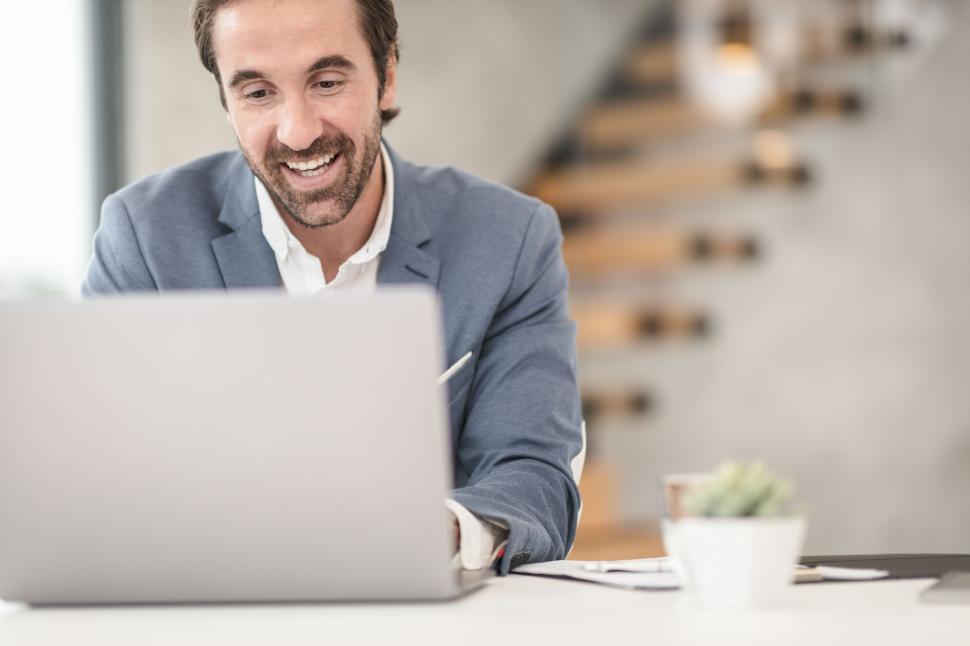 hombre feliz escribiendo en una laptop dentor de la empresa