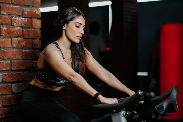 mujer haciendo ejercicio sobre una bicicleta en el gimnasio para la salud mental