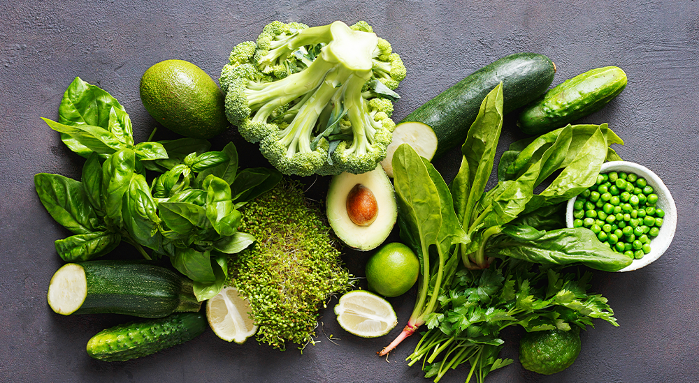 muchas verduras verdes aguacate brocoli pepino garbanzos sobre una mesa